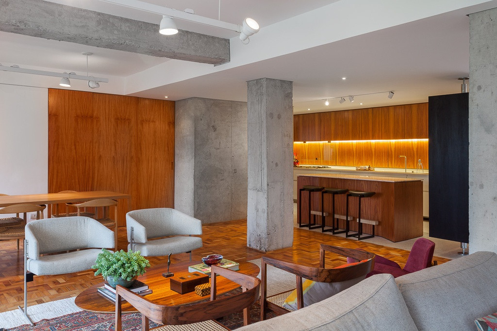 Khu vực bếp được thiết kế mở ra phòng khách với hệ đèn ấm áp và chất liệu gỗ.