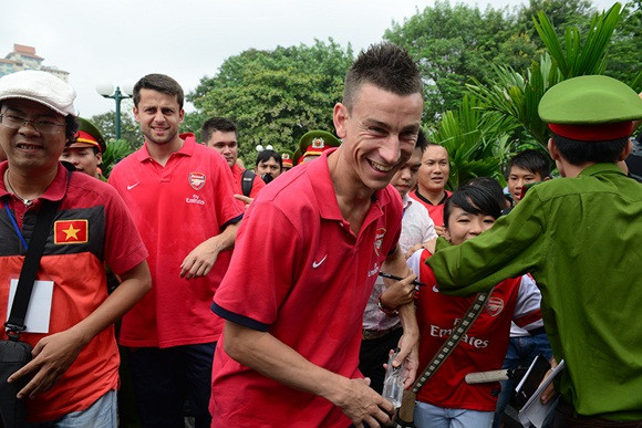 Tại chùa Trấn Quốc, ba chàng “ngự lâm pháo thủ” đã được HT.Thích Thanh Nhã (trụ trì chùa Trấn Quốc) dẫn đi vãn cảnh chùa và thắp hương lễ bái. Bước đầu, cả ba cầu thủ đều tỏ ra khá lúng túng trước các nghi lễ khi vào chùa. Và phải nhờ đến sự chỉ dẫn của HT.Thích Thanh Nhã, các cầu thủ Arsenal mới có thể hiểu phần nào. Qua những chuyến viếng thăm như vậy, nét đẹp truyền thống của Việt Nam đã có dịp quảng bá đến bạn bè thế giới. Ảnh: Vừa xuống xe, anh đã bị giật mình bởi một CĐV nữ níu tay lại.