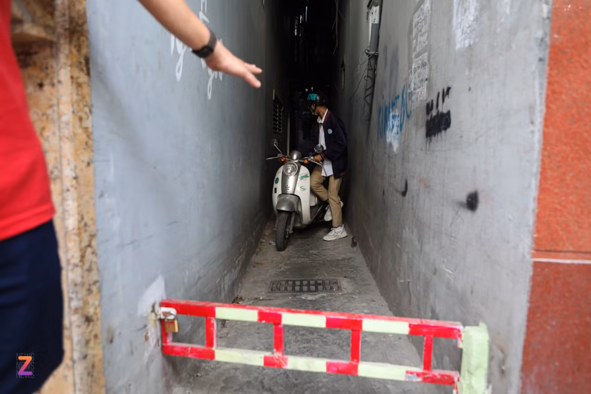 "Trước đây khi chưa làm rào chắn, nhiều phương tiện muốn đi từ Thượng Đình vào phố Tây Sơn phải rẽ vào đường Trường Chinh rồi vòng ngược lại, vì vậy họ đã đi tắt qua ngõ, cắt ngang đường lên cầu vượt Ngã Tư Sở. Chúng tôi không muốn phải làm thế này, nhưng người dân trong ngõ phải chịu cảnh ùn tắc, ồn ào mỗi sáng sớm, người già, trẻ nhỏ đi bộ còn bị các phương tiện gây tai nạn rất mất an toàn, xảy ra những tranh cãi không đáng có nên đành phải dựng rào chắn để hạn chế phương tiện lưu thông", ông Thanh nói. Trong ảnh là một học sinh muốn xin mở rào chắn tại ngõ 94 Thượng Đình để đi học nhưng bị yêu cầu quay đầu tìm hướng khác.