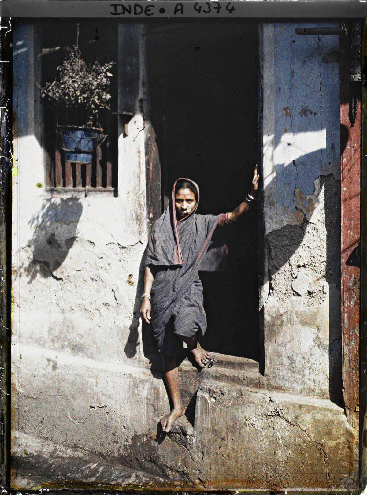 Người phụ nữ mặc sari - trang phục truyền thống của phụ nữ Ấn Độ - đứng trước cửa nhà.