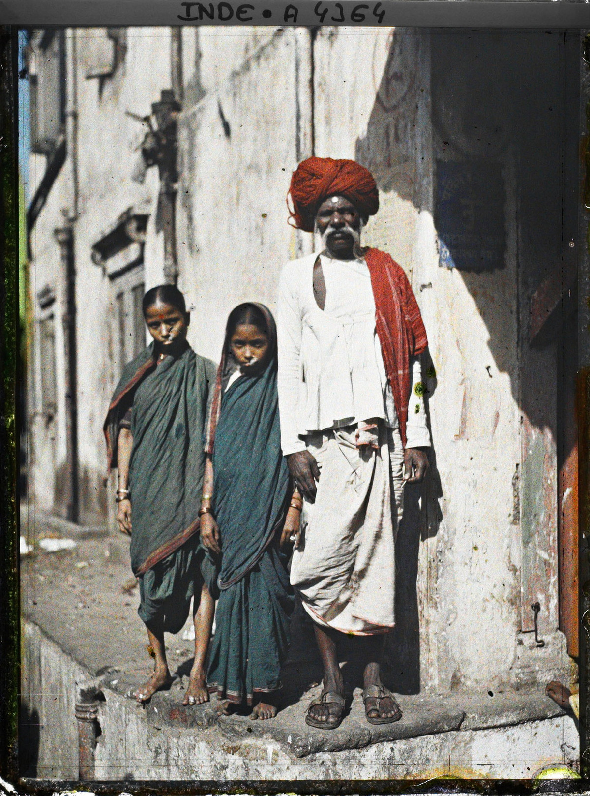 Người đàn ông và hai thiếu nữ trên phố.