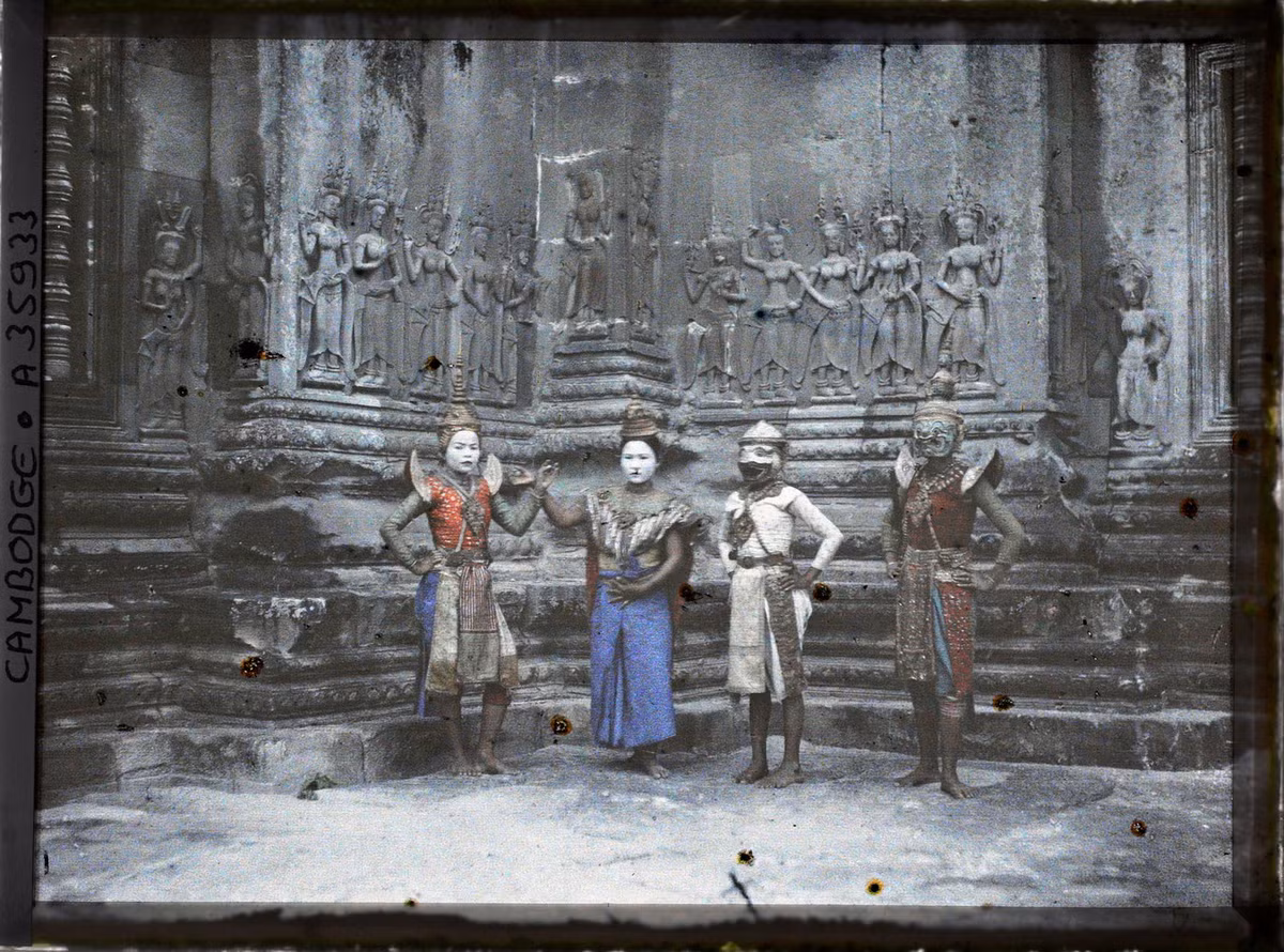 Các vũ công tạo dáng trước một nhóm tượng vũ nữ apsara.