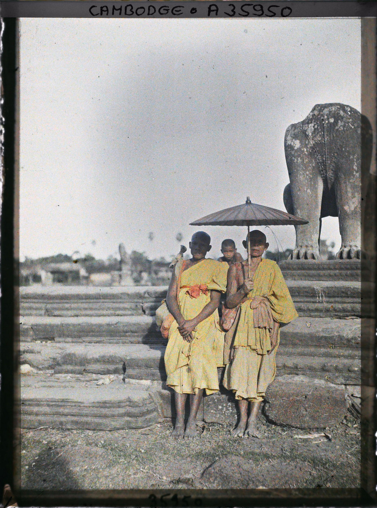 Hai nhà sư hành hương che nắng bằng ô.