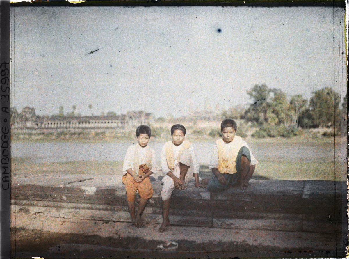 Những đứa trẻ Khmer ngồi bên bờ hào.