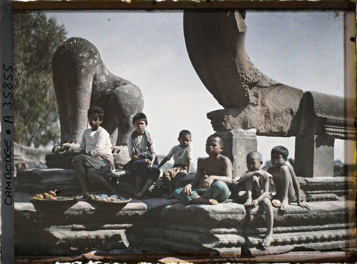 Nhóm trẻ em bên những bức tượng không còn nguyên vẹn.