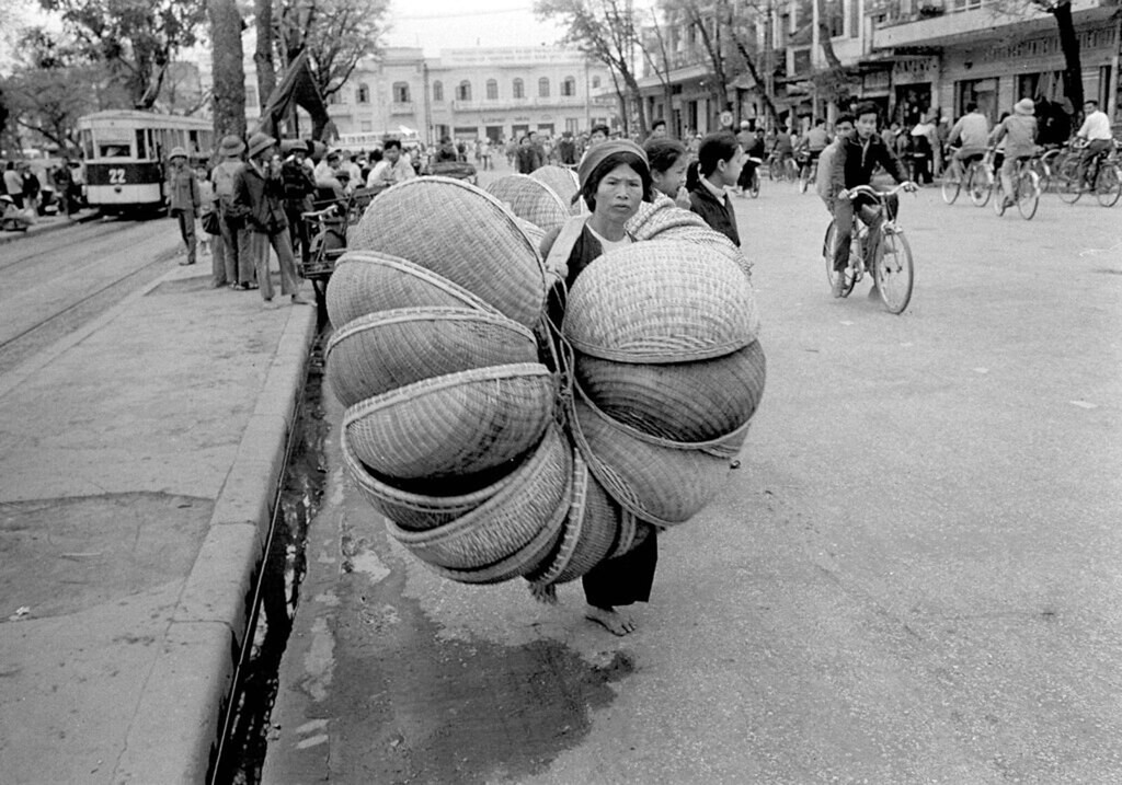 Người phụ nữ gánh thúng mẹt đi bán ở khu vực ga tàu điện bờ hồ Hoàn Kiếm, 16/3/1973.