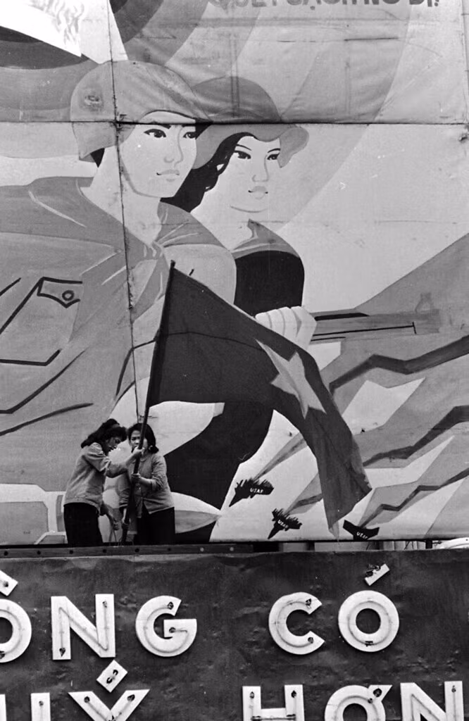 Hai người phụ nữ cắm cờ Tổ quốc ở tòa nhà góc Tràng Tiền - Đinh Tiên Hoàng, 3/4/1973.