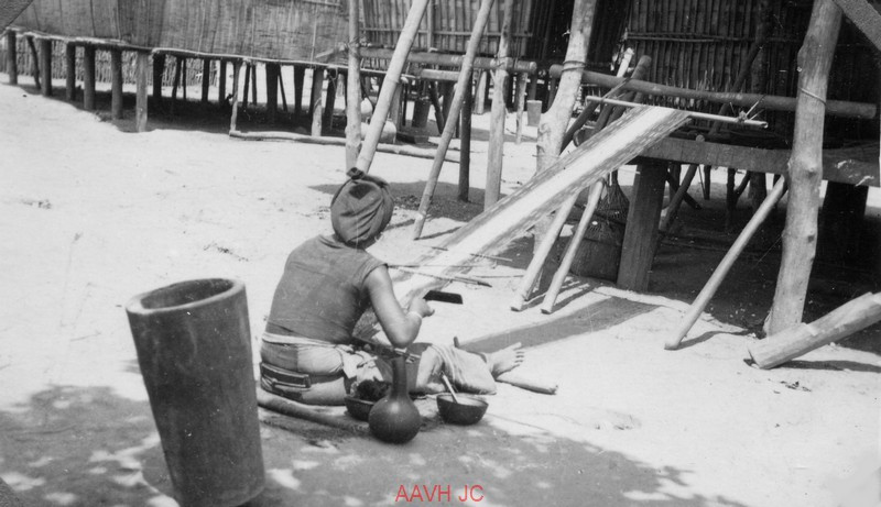 Một người dân bản dệt vải dưới nhà sàn.