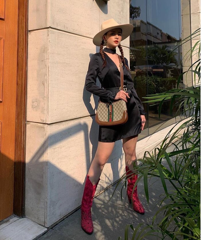 Thời trang lấy cảm hứng từ miền viễn Tây nước Mỹ được Chi Pu chinh phục xuất sắc khi cô diện váy đen xẻ ngực, thắt tóc bím hai bên cùng chiếc mũ cao bồi. Vẻ khoáng đạt, phong trần của thời trang cao bồi được tô điểm thêm đôi boots đỏ đặc sắc nổi bần bật
