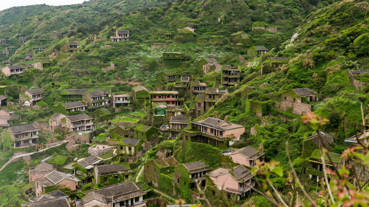  Hậu Đầu Loan, Trung Quốc: Nằm trên đảo Thặng Sơn ngoài khơi bờ biển phía đông Trung Quốc, làng chài Hậu Đầu Loan hẻo lánh trở nên um tùm sau khi các căn nhà bị bỏ hoang vào những năm 1990. Cảnh tượng độc lạ với những ngôi nhà bị "nuốt chửng" bởi thảm xanh của tán lá và cây thường xuân hòa vào các sườn đồi. Trong khi phần lớn ngôi làng bị bỏ hoang, số lượng nhỏ dân cư vẫn tiếp tục sinh sống tại đây và kiếm tiền từ ngành du lịch. Ảnh: Philipgiancola.