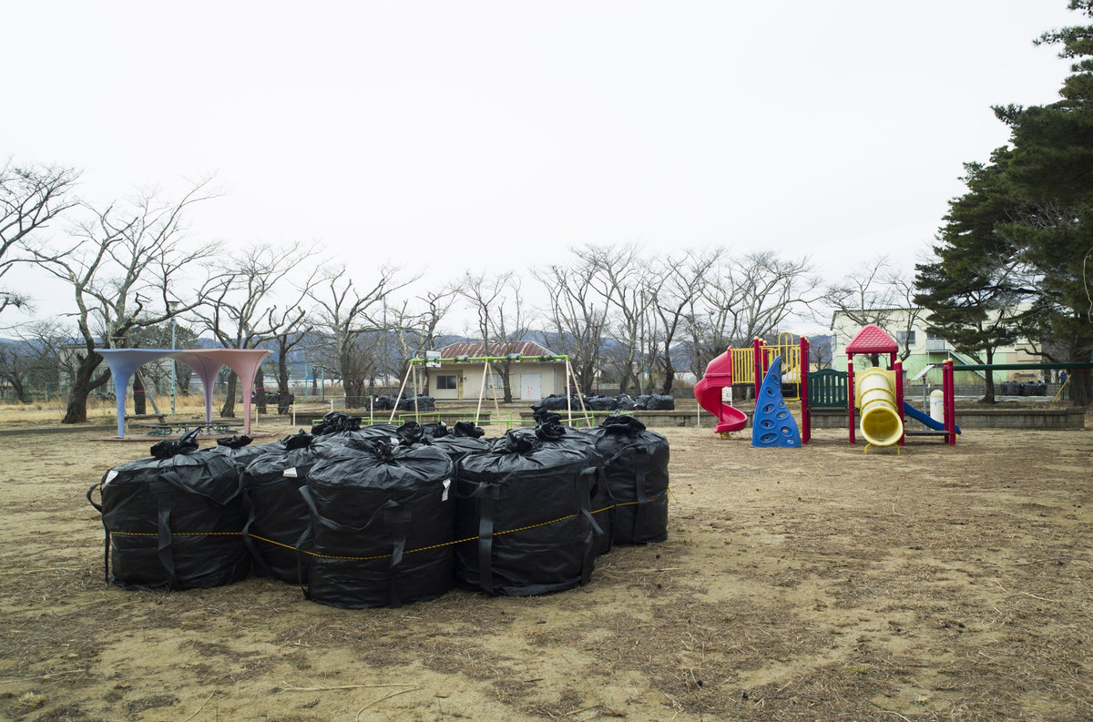 Nửa còn lại làm bãi chứa chất thải hạt nhân. Khu vực này đầy những túi đen đựng đất phóng xạ, cành cây và các mảnh vụn ô nhiễm khác được thu thập từ khắp thị trấn. Những chiếc túi cuối cùng sẽ được gửi đến cơ sở lưu trữ chất thải trung hạn ở Futaba và Okuma, 2 thị trấn có nhà máy hạt nhân.