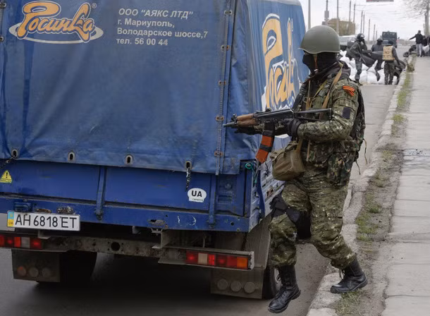 Một chiến binh có vũ trang lục soát ô tô khả nghi.