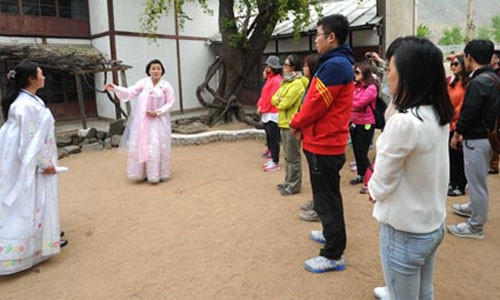 Các du khách Trung Quốc đang lắng nghe các hướng dẫn viên nói về một địa điểm tham quan du lịch ở Triều Tiên ngày 2/5.