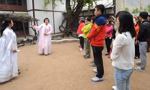 Các du khách Trung Quốc đang lắng nghe các hướng dẫn viên nói về một địa điểm tham quan du lịch ở Triều Tiên ngày 2/5.