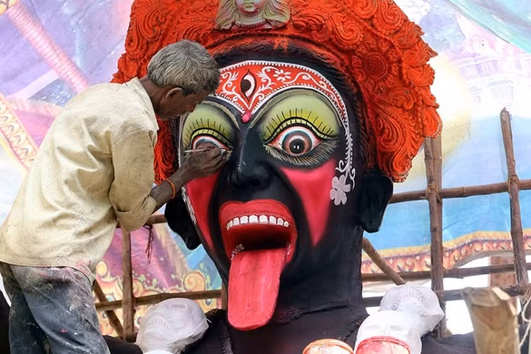 Một nghệ nhân Ấn Độ "trang điểm" cho Nữ thần Kali vào dịp Lễ hội Navratri ở Bhopal.