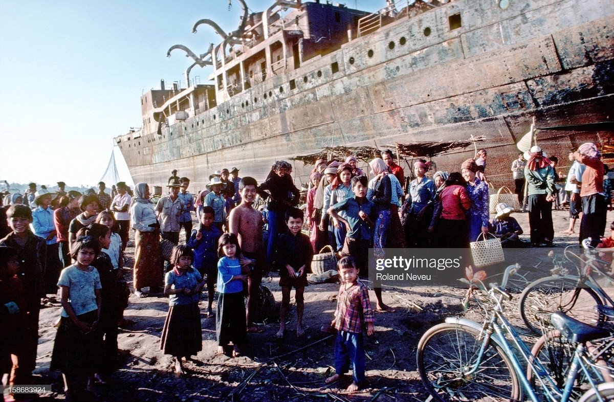 Khung cảnh tại một khu chợ họp cạnh xác con tàu trên bờ sông Mekong.