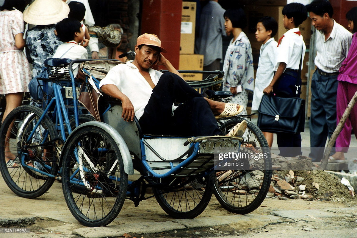 Người lái xích lô đợi khách trên vỉa hè.