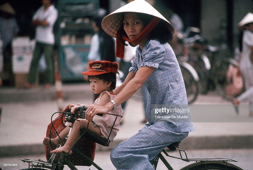 Bà mẹ chở con nhỏ trên xe đạp, TP. HCM năm 1989.