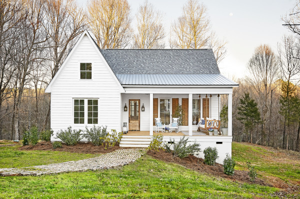 Ngôi nhà màu trắng tinh khôi nổi bật trên nền xanh của cây cối, thảm cỏ. Một chút tiểu cảnh như ghế ngồi, hoa cỏ ở trước sân giúp căn nhà thêm phần lãng mạn