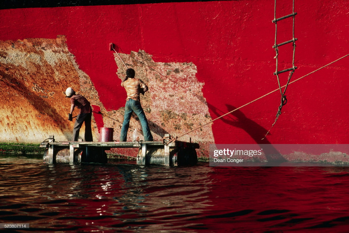 Các công nhân sơn lại mạn thuyền ở cảng Singapore.