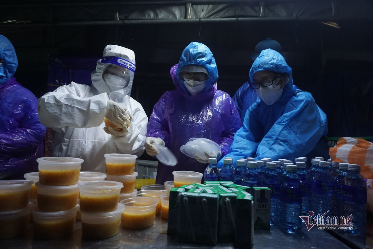 Mặc bộ áo mưa tiện lợi mỏng manh mọi người tranh thủ ăn vội để di chuyển xuống đèo đến tỉnh Thừa Thiên - Huế. Nhiều người cho biết, hôm nay thời tiết chuyển mưa, lạnh nên việc di chuyển càng khó khăn hơn.. Thức ăn, nước uống được lực lượng chức năng Đà Nẵng chuẩn bị sẵn