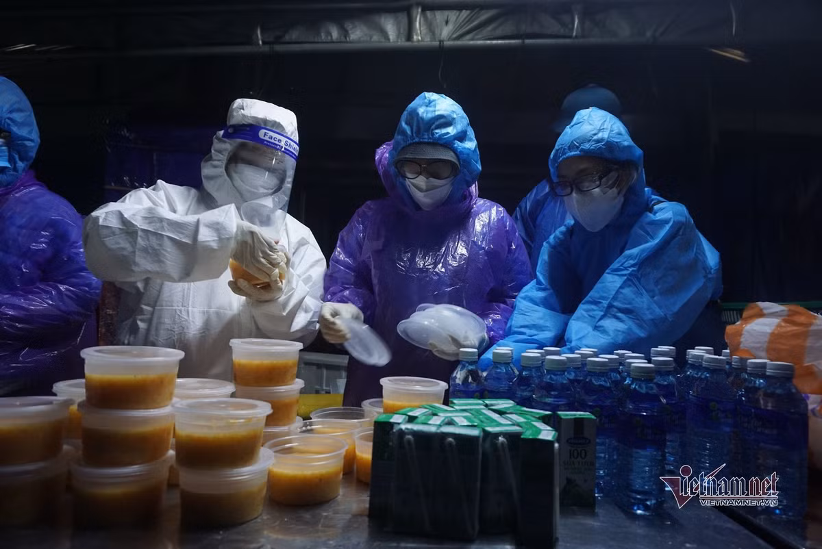 Mặc bộ áo mưa tiện lợi mỏng manh mọi người tranh thủ ăn vội để di chuyển xuống đèo đến tỉnh Thừa Thiên - Huế. Nhiều người cho biết, hôm nay thời tiết chuyển mưa, lạnh nên việc di chuyển càng khó khăn hơn.. Thức ăn, nước uống được lực lượng chức năng Đà Nẵng chuẩn bị sẵn