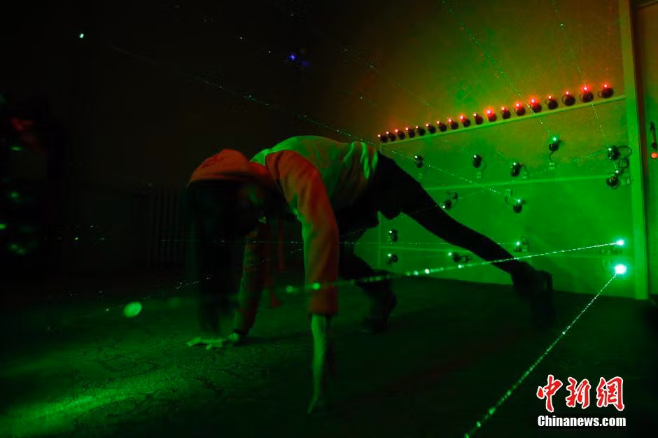 Người chơi cần phải rất can đảm mới có thể vượt qua những thử thách. Bạn nữ đang tìm cách lách qua hàng rào tia laze.