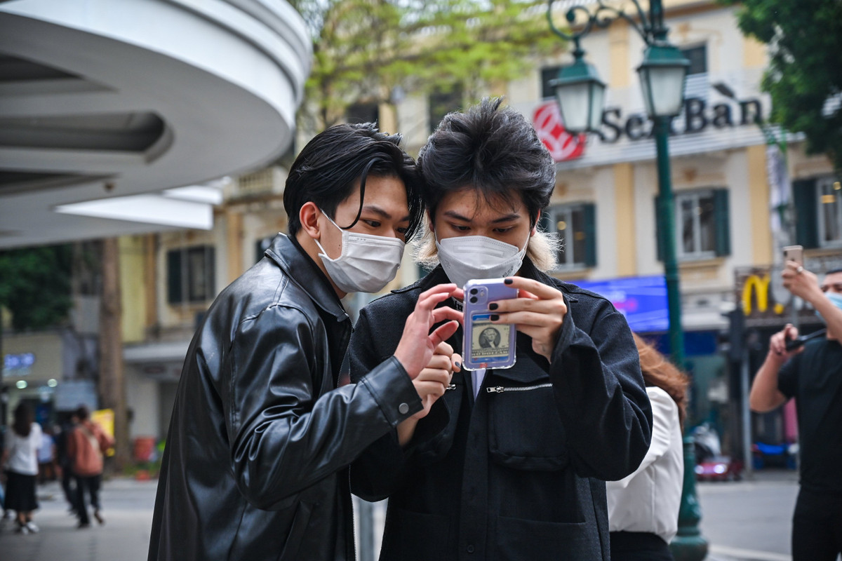 Vừa mới khỏi bệnh Covid-19 cách đây một tuần, Huy (20 tuổi, bên phải) biết tin phố đi bộ hoạt động trở lại liền rủ bạn bè lên phố chơi ngay. "Ở nhà nhiều khiến em cũng cuồng tay chân", Huy nói.