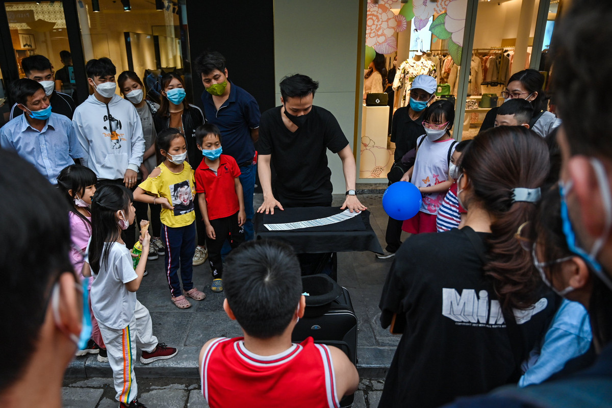 Nhiều hoạt động vui chơi thu hút trẻ nhỏ và cả người lớn. Trong ảnh, một thanh niên biểu diễn ảo thuật trên vỉa hè.