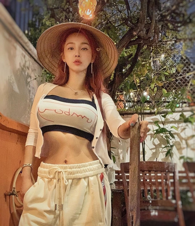 DJ Hàn Quốc xinh đẹp tự tin diện kiểu áo quây kết hợp với quần chun cạp cao.