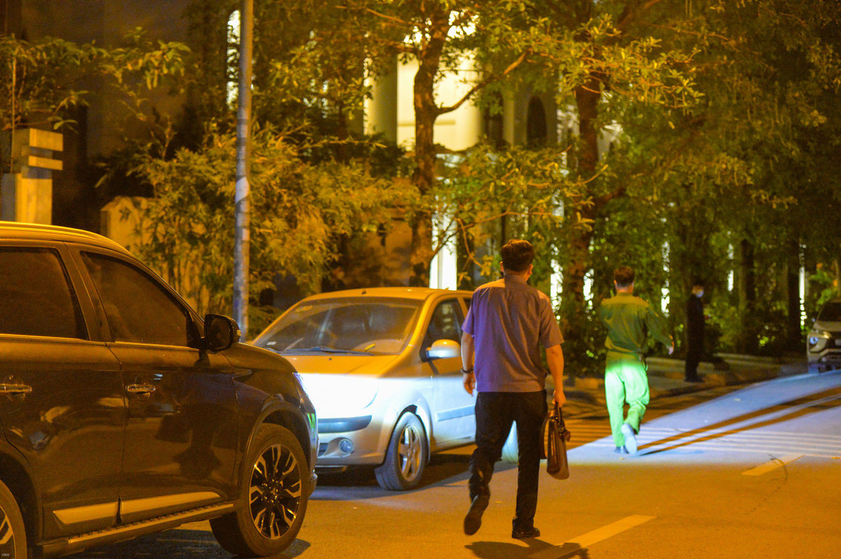 Khoảng 18h50, lực lượng chức năng tiến vào căn biệt thự trong Khu đô thị Mỹ Đình 2, quận Nam Từ Liêm, Hà Nội. Bên ngoài, một vài người mặc áo thường phục in chữ "FLC Land - Security" cầm bộ đàm, ngăn các phóng viên ghi hình. Ảnh: Hoàng Lam.