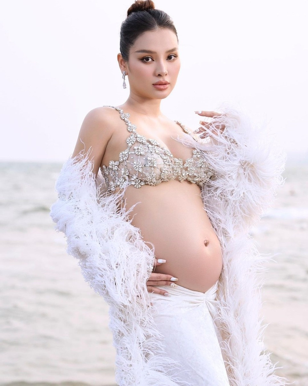 Phương Trinh Jolie sinh con cuối tháng 6 vừa qua. Nữ diễn viên lăng xê gu thời trang gợi cảm, táo bạo khi mang bầu lần hai. Cô phối áo bra xuyên thấu đính kết bắt mắt, kèm chân váy và áo lông vũ (Ảnh: @phuongtrinhjolie).