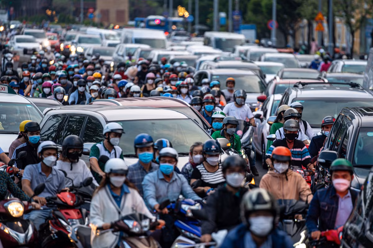 Xe máy kín đặc, chen nhau nhích từng chút giữa làn xe hơi đông không kém.