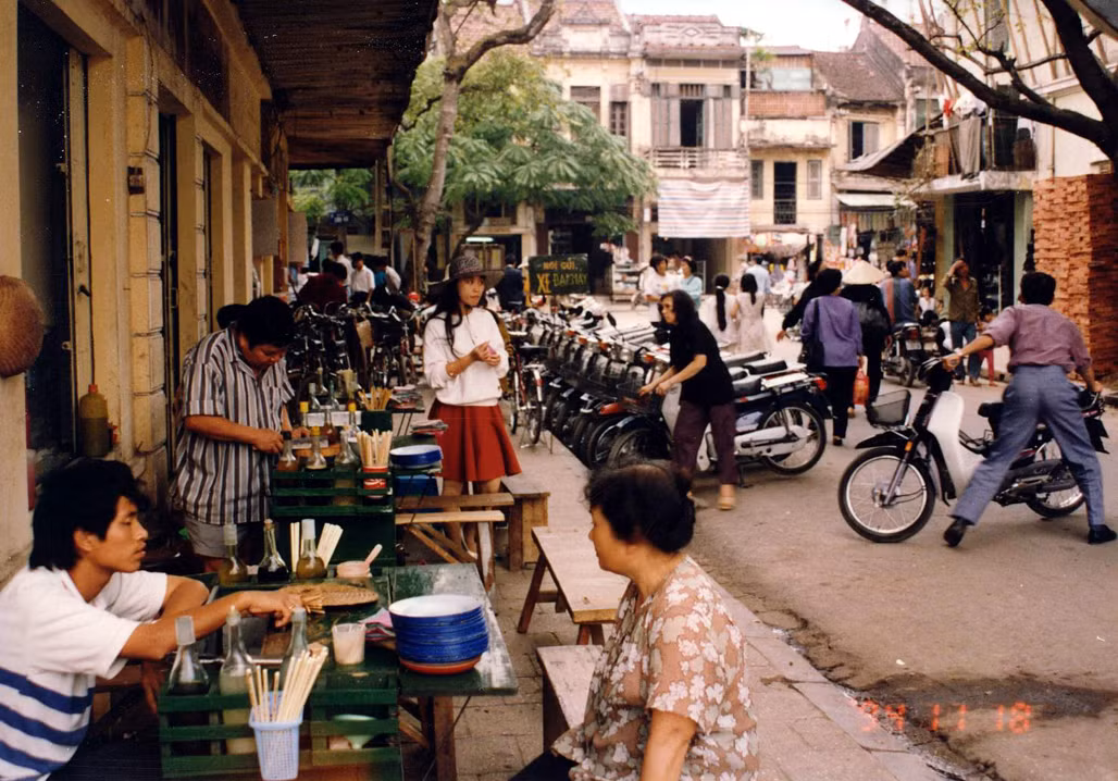 Một quán ăn vỉa hè. Những chiếc Honda Dream mới coóng dựng bên lề đường.