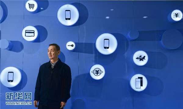 Hou Weigui đứng ở gian hàng trưng bày sản phẩm do tập đoàn ZTE sản xuất. Tính tới năm 2013, ông Hou đã giữ chức chủ tịch ZTE hơn 16 năm.