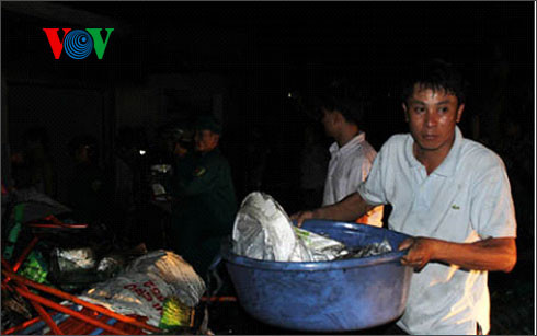 Hàng hóa được di chuyển ra bên ngoài. Tiểu thương sơ tán hàng hóa ra bên ngoài và phủ bạt để bảo vệ qua đêm.