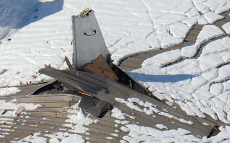 Đuôi một chiếc P-3C chọc thủng trần nhà bị sập.