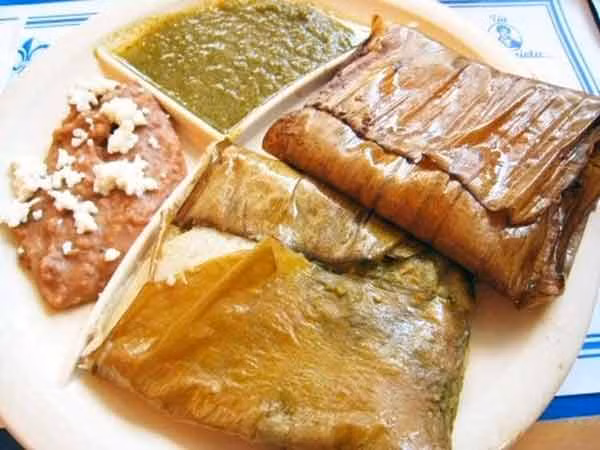 8. Tamales. Tamales là một món ăn Mexico khá giống với bánh tét, bánh ít của Việt Nam được làm từ bột ngô trộn với mỡ, thịt, cá, rau. Tất cả các nguyên liệu này được gói trong lá chuối hoặc lá ngô và nấu chín bằng hơi. Mỗi khu vực của Mexico có các loại tamales khác nhau nhưng nổi tiếng nhất là loại tamales Oaxacan với nhân kèm nước sốt chocolate.