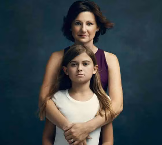 Diane Rose, 45 tuổi, ở Philadelphia. Diane chia sẻ: “Sau khi dì của tôi được chẩn đoán ung thư buồng trứng giai đoạn 4 ở tuổi 50 và đột biến gen BRCA, cả 4 anh em chúng tôi đã quyết định cùng nhau đi xét nghiệm. Sau khi biết mình có nguy cơ mắc bệnh cao, tôi quyết định phẫu thuật cắt bỏ và tái tạo ngực ngay sau đó. Sự lo lắng trước khi phẫu thuật đến rất mãnh liệt, nhưng khi bạn thức dậy, bạn đã ở trong một trạng thái hoàn toàn mới – cảm giác nhẹ nhõm hơn rất nhiều. Và chính tôi đã kiểm nghiệm được điều đó”. Diane chụp ảnh chung với con gái Ellie, 10 tuổi.