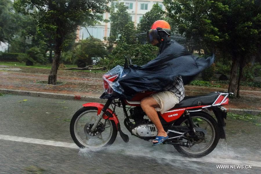 Một người dân ở thành phố Tam Á phi xe máy trong cơn mưa lớn.