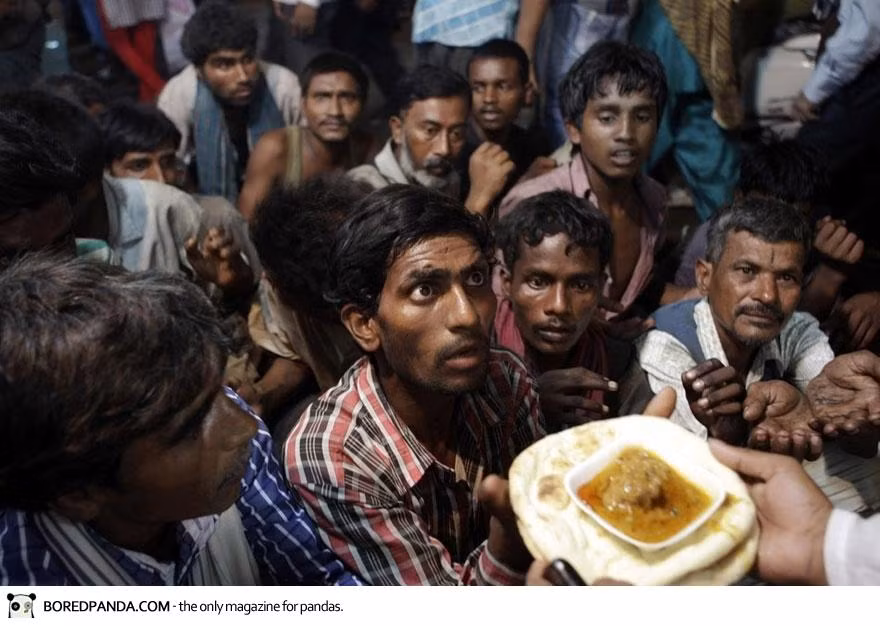 Những người vô gia cư Ấn Độ đang đợi đến lượt nhận bữa ăn miễn phí bên ngoài thánh đường Eid al-Fitr ở New Delhi.