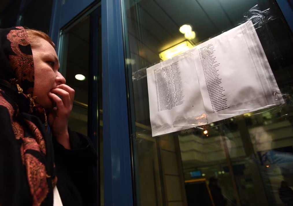 Một phụ nữ nén lòng xem danh sách những hành khách có mặt trên chuyến bay tử thần được dán tại sân bay Kazan.