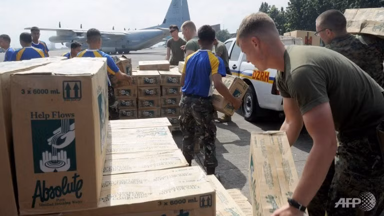 Binh sĩ Mỹ và Philippines xếp hàng cứu trợ để chuẩn bị chuyển tới người dân vùng bị ảnh hưởng bởi siêu bão Haiyan.