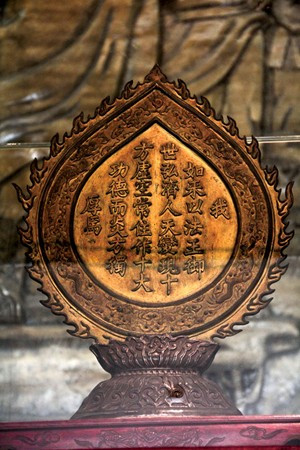 Chúng ta sẽ thấy sự pha trộn ấy thể hiện khá rõ ở những hiện vật quý giá ở các chùa xứ Quảng. Đây là dịp rất hiếm để được xem những sắc thái phong phú trong tạo hình tượng Phật của các nghệ nhân cách đây vài thế kỷ. Ảnh: Trái tim lửa bằng đồng rập ngự bút của Minh Mạng ghi nhận lòng thành kính của người nước Nam trước Đức Phật Tổ. Quả tim lửa này được để tại chùa Tam Thai xây dựng từ năm 1630, được vua Minh Mạng ban sắc tứ, cổ tự là quốc tự của triều đình và ban cho chiếc kim bài quý. 200 năm qua, quả tim lửa này là một báu vật trong đời sống tâm linh của người dân sống trong vùng Ngũ Hành Sơn. Các chuyên gia Bảo tàng Đà Nẵng đã có kế hoạch nghiên cứu và làm hồ sơ đề xuất công nhận chiếc kim bài này là bảo vật quốc gia.