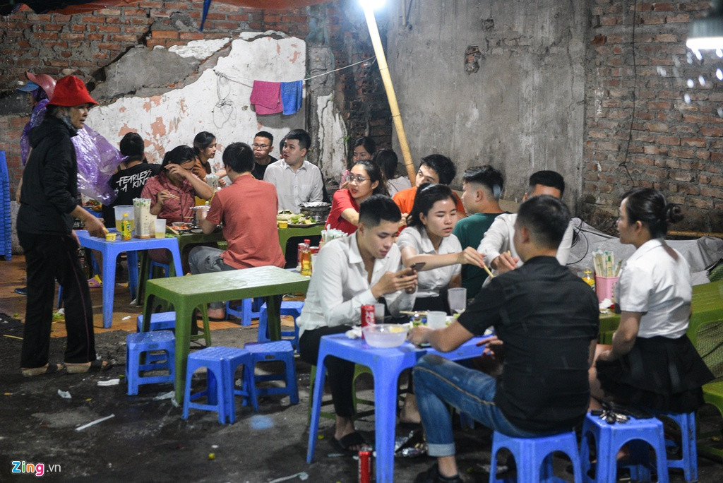 Cửa hàng bán các món lẩu, nướng với không gian chật hẹp, ẩm ướt trên phố Cát Linh gần như kín chỗ vào lúc 21h. Họ ăn uống, nói chuyện tự nhiên, bất chấp việc tiềm ẩn nguy cơ lây nhiễm Covid-19 ở những nơi đông người.