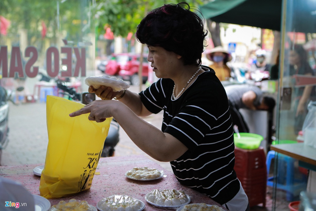 Bà Phạm Kim Oanh đang sắp xếp đơn hàng để giao. Chỉ trong một buổi sáng, khoảng 100 đĩa bánh đã được bà chuyển đi cho khách. "Nhà tôi bán bánh trôi, bánh chay cả ngày thường nên toàn khách quen đặt mua. Giá bánh giữ nguyên, từ 10.000-20.000 đồng/đĩa", bà cho biết.