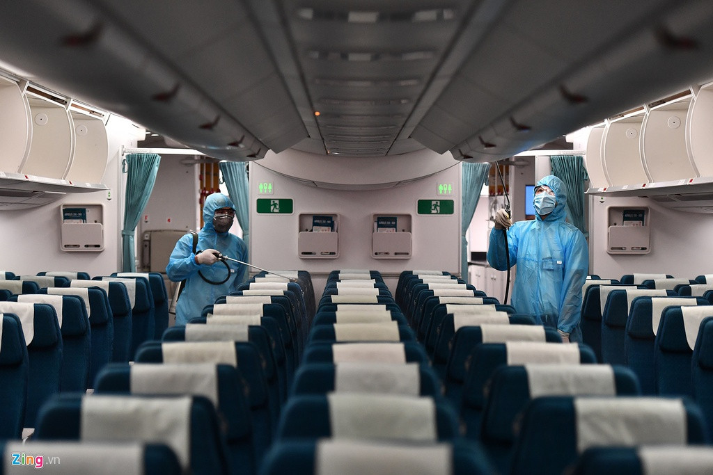 Trong ảnh là chiếc Airbus A350-900 vừa hạ cánh xuống sân bay Nội Bài (Hà Nội) từ Tân Sơn Nhất (TP.HCM). Các công nhân khử trùng theo quy trình gồm hai bước cơ bản là phun khử trùng tàu bay và lau chùi vệ sinh trang thiết bị bằng dung dịch chuyên dụng.