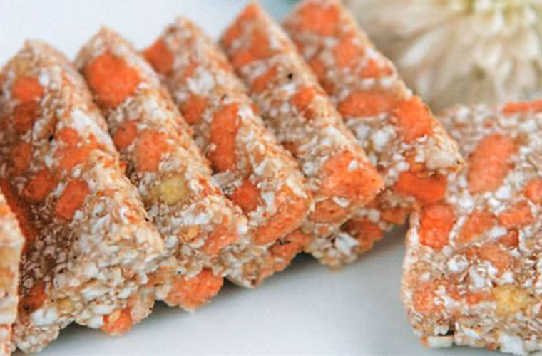 Bánh được làm từ gạo nếp và các nguyên liệu phụ khác như gấc, lạc, vừng, cà rốt, gừng, vỏ quýt, mỡ lợn… Khi cắt, bánh có màu vàng trắng xen lẫn hồng cam trông giống như trứng loài chim cáy.