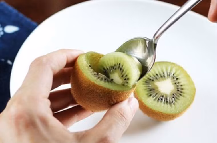 Quả kiwi. Việc dùng dao gọt từng mảnh vỏ sẽ mất thời gian và không đảm bảo vệ sinh bằng cách cắt đôi trái kiwi ra rồi dùng thìa múc từng miếng để ăn.