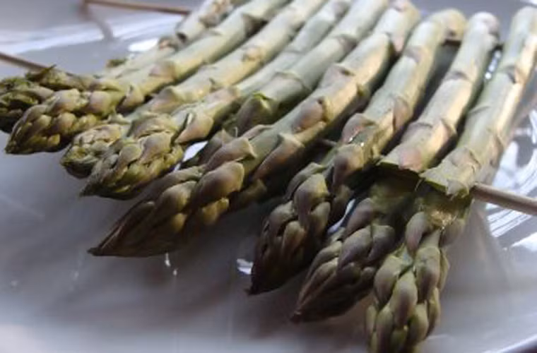 Một tay giữ lấy thân măng, tay còn lại cầm chắc xiên tre để gắn từng cây lại với nhau.